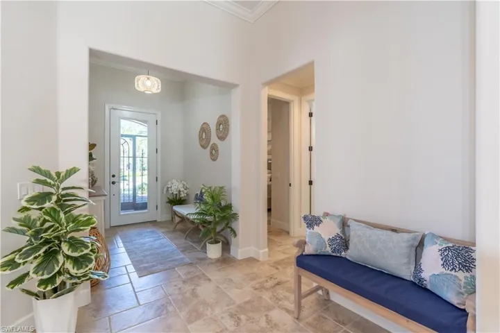 Entryway with crown molding and stone tile flooring
