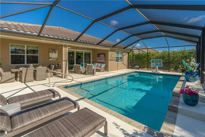 Swimming pool with outdoor lounge area, a sunroom, a patio area, glass enclosure, and outdoor dining space