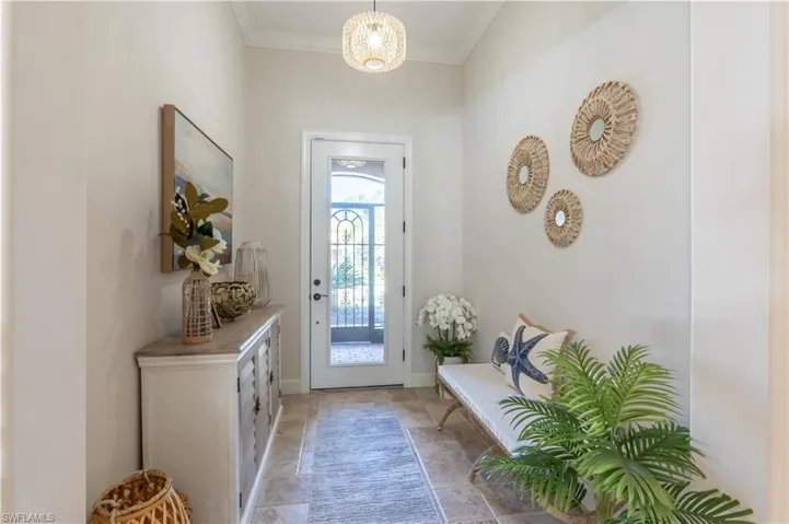 Doorway featuring ornamental molding and baseboards