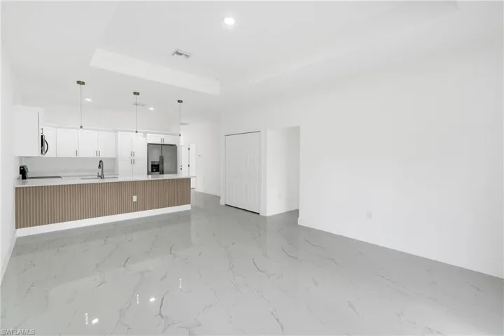 Unfurnished living room with a tray ceiling and recessed lighting