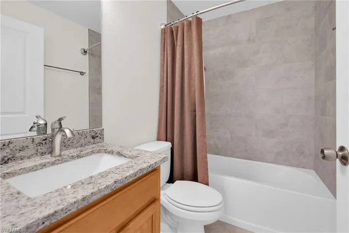 Bathroom featuring shower / tub combo with curtain and vanity