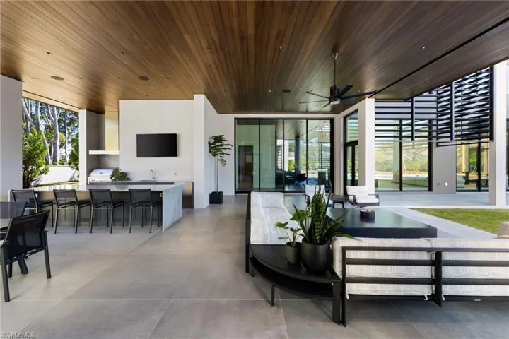 View of patio with outdoor lounge area, ceiling fan, grilling area, area for grilling, and a wet bar