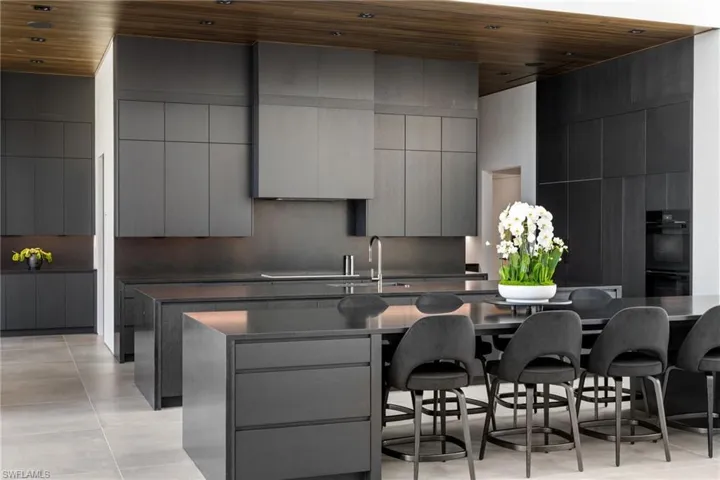 Kitchen with gray cabinetry, sink, wood ceiling, and a breakfast bar