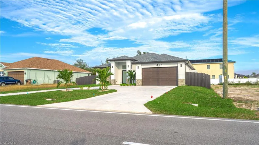 View of front of property with a garage and a front yard