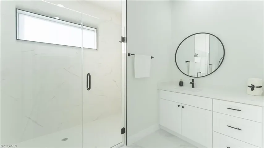 Bathroom with a shower with shower door and vanity