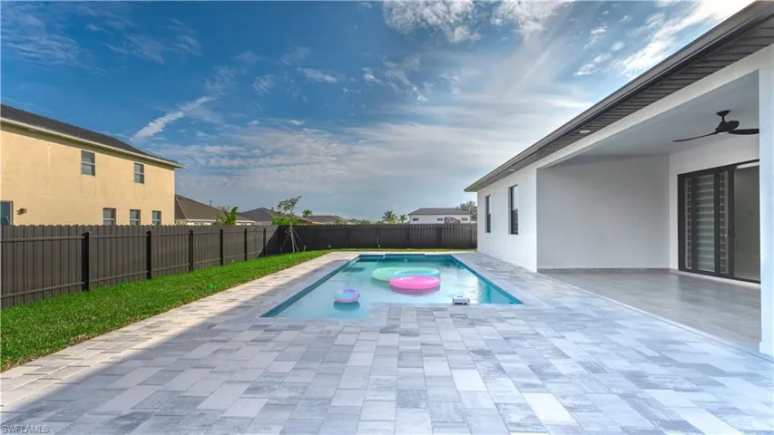 View of pool with ceiling fan and a patio