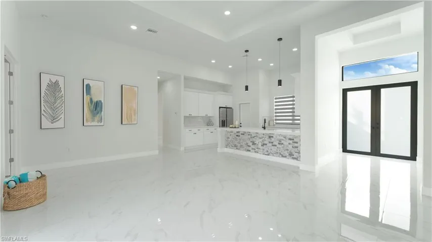 Unfurnished living room with sink and french doors