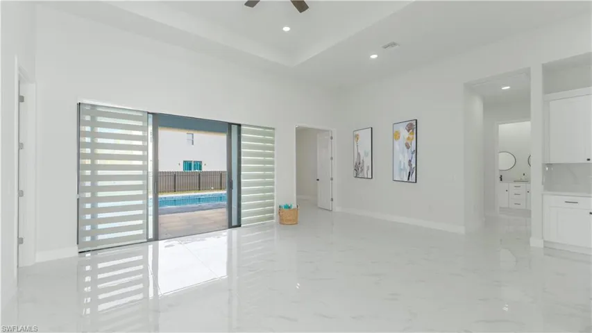 Empty room featuring ceiling fan and a towering ceiling