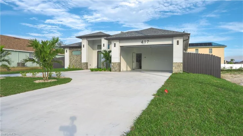 View of front of home featuring a front lawn and a garage