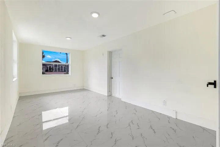 Empty room featuring light marble finish flooring and baseboards
