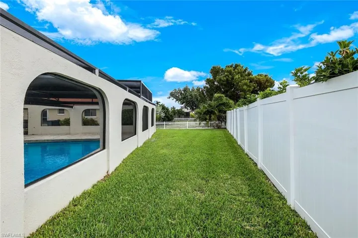 Fenced backyard featuring a ceiling fan and a patio