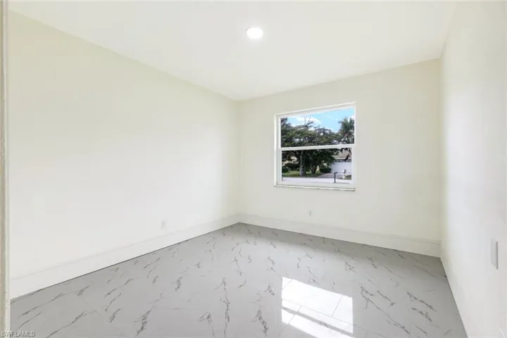 Empty room featuring marble look tile flooring and recessed lighting