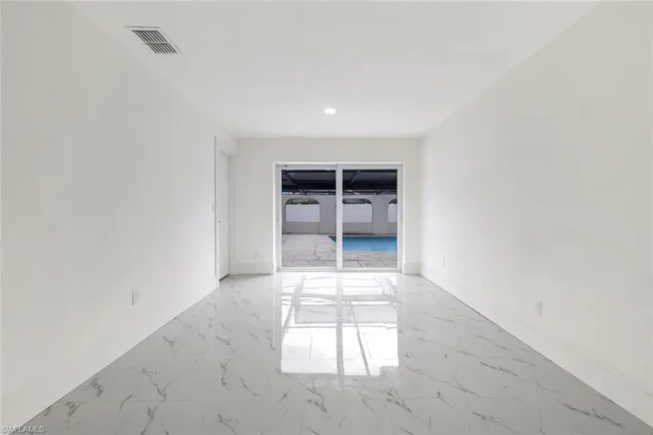 Unfurnished room with light marble finish floors and recessed lighting
