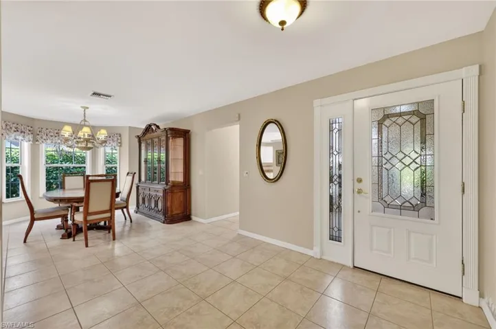 Foyer with hanging lights and light tile flooring