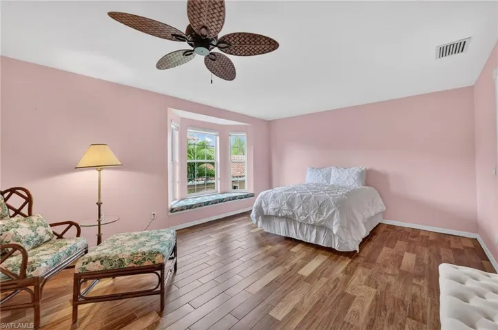 Bedroom with wood-look tile finished floors and ceiling fan