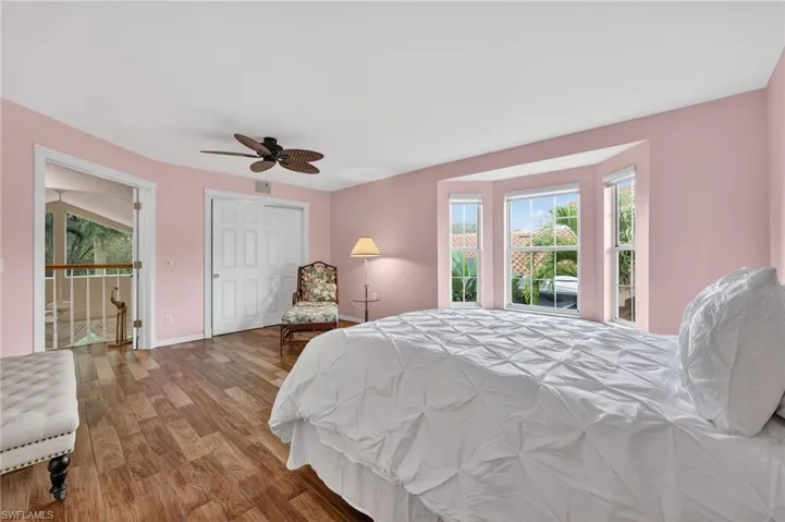 Bedroom featuring wood-look tile finished floors, a ceiling fan, and a closet