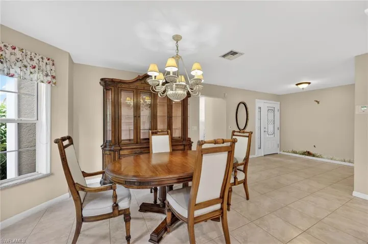 Dining space featuring suspended lighting and light tile floors