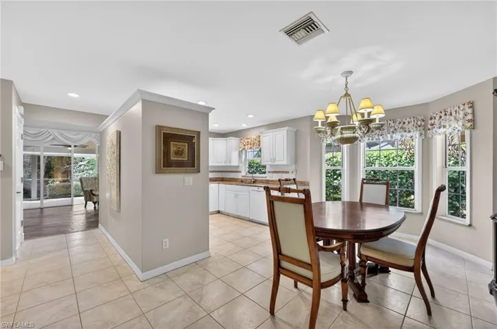 Dining room with suspended lighting, healthy amount of natural light, and light tile floors