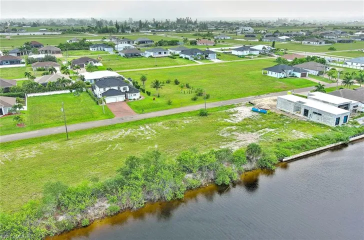 Aerial perspective of suburban area featuring a nearby body of water