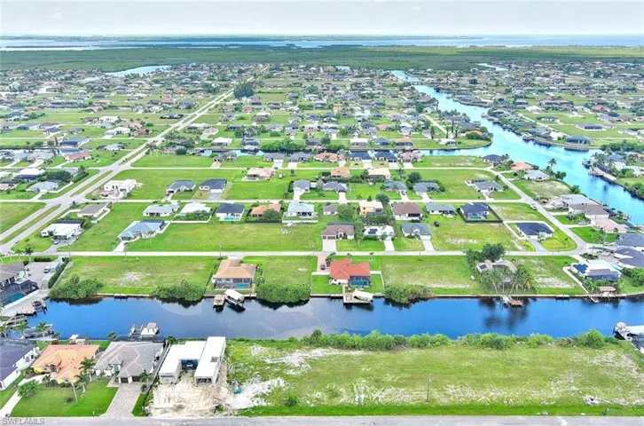 Aerial view of property and surrounding area with nearby suburban area and a nearby body of water