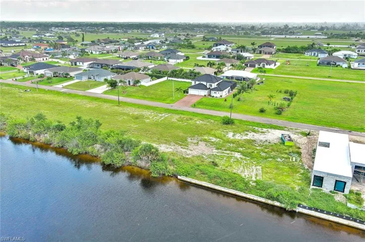 Aerial perspective of suburban area featuring a nearby body of water