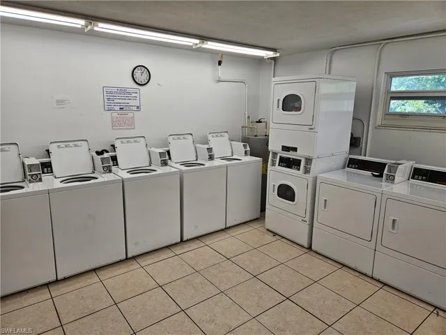 Laundry area featuring stacked washer and dryer, washer and clothes dryer, a textured ceiling, and light tile patterned floors