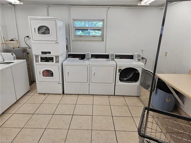 Washroom with separate washer and dryer, stacked washer and dryer, and light tile patterned floors