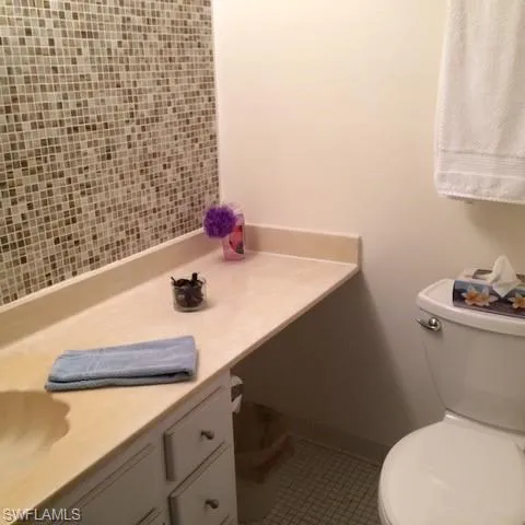 Bathroom featuring vanity, tile patterned flooring, and toilet