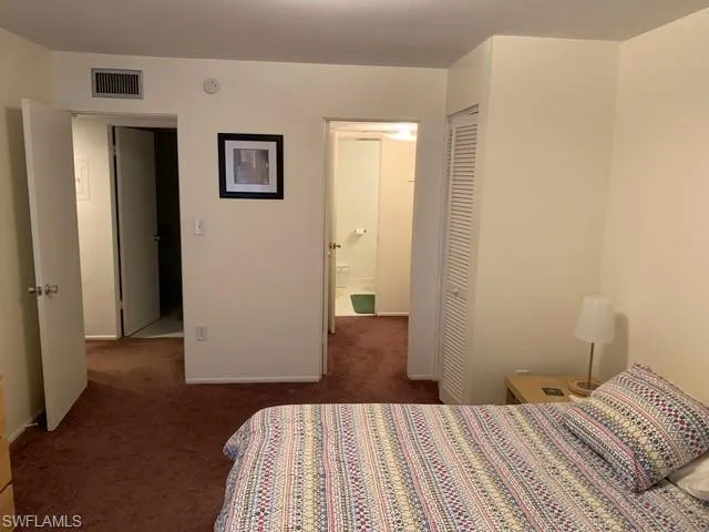 Carpeted bedroom featuring a closet