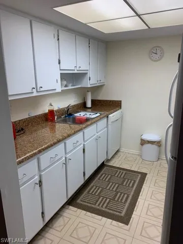 Kitchen featuring white cabinetry, dishwasher, sink, and refrigerator