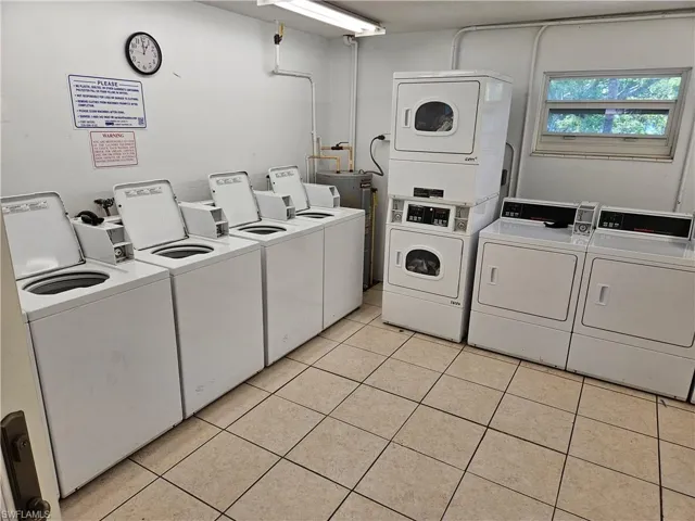 Laundry area with washing machine and clothes dryer and light tile patterned floors