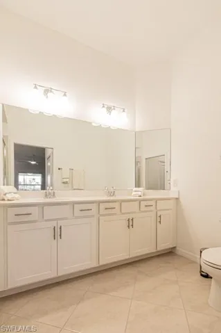 Full bath with tile patterned floors and double vanity