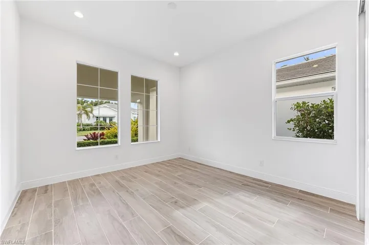 Spare room with light wood-style flooring, baseboards, and recessed lighting