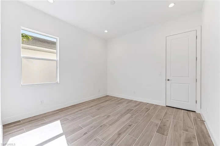 Empty room with recessed lighting, baseboards, and light wood-style flooring