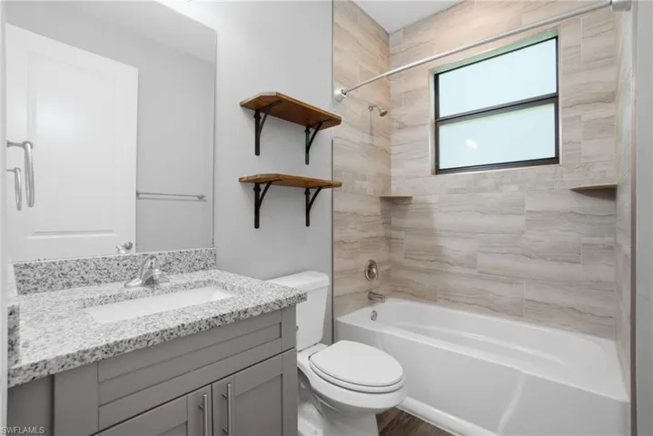 Bathroom 2 - both bathrooms offer gray cabinetry, granite counter tops & gorgeous marbled white tile in the shower/bath.