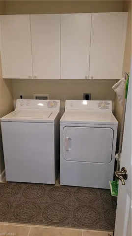 Laundry area with cabinet space and washer and clothes dryer
