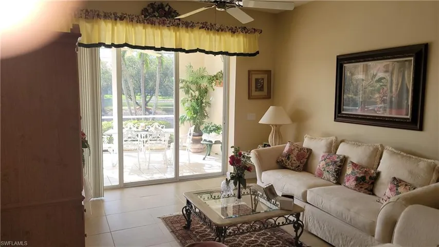 Living room featuring light tile patterned flooring and ceiling fan