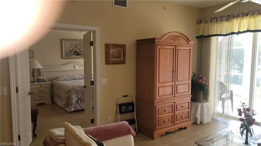 Bedroom with access to exterior, light tile patterned floors, and visible vents