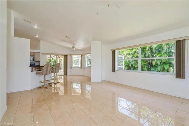 Family room with tile floors throughout and sliders to lanai/pool