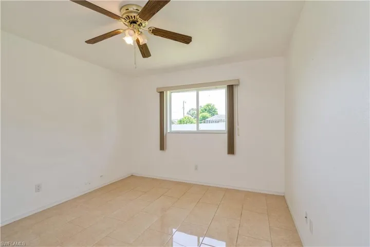 Guest bedroom with tile floors and natural lighting