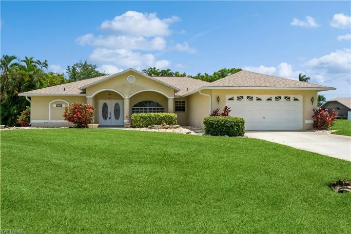 Ranch-style house with a front yard and a garage