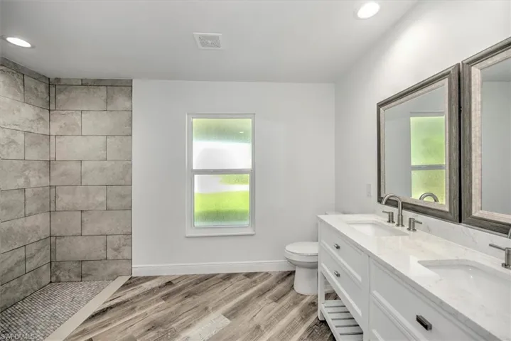 Master bathroom has a nice shower with large plank tile walls dual sinks with lots of storage.