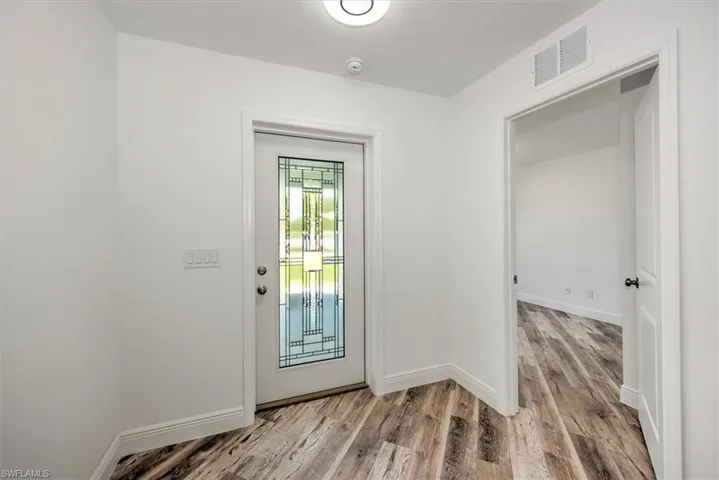 Entry view with a bedroom to the right of the picture. This would make a great kids play area or a fantastic office.