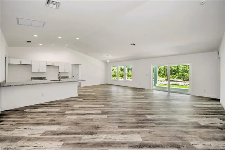 View from the entry with the kitchen to the left, dining back corner and sliders to the lanai.