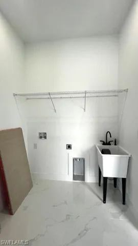 Washroom with tile patterned floors and hookup for a washing machine