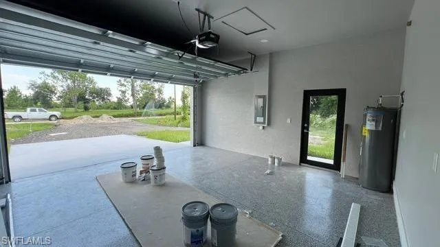 Garage featuring electric panel and water heater