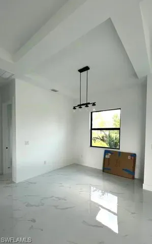 Spare room featuring beamed ceiling and tile patterned flooring