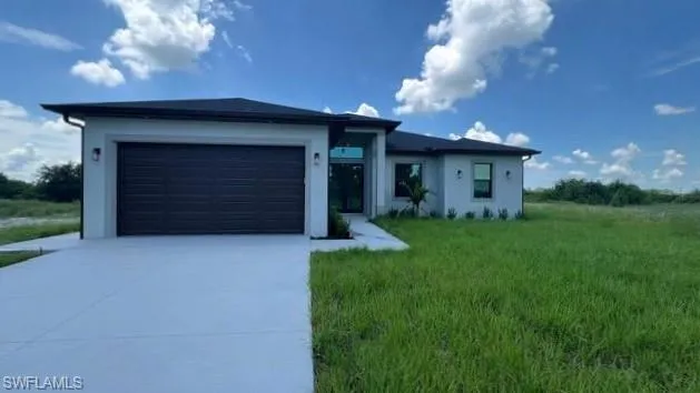 Ranch-style house with a garage and a front yard
