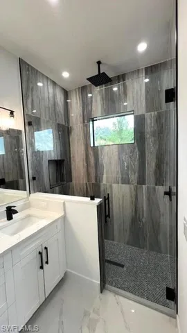 Bathroom with vanity, tile patterned flooring, and an enclosed shower