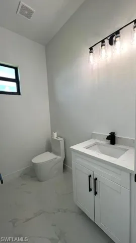 Bathroom with vanity, toilet, and tile patterned floors